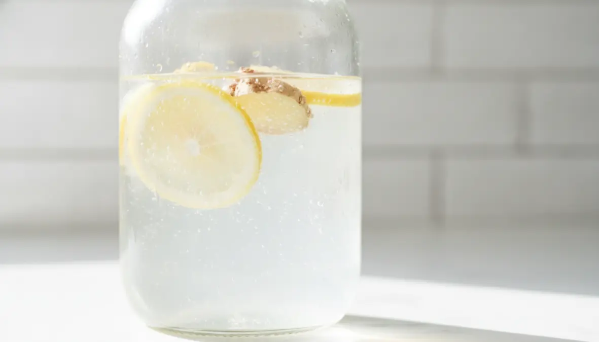 Acqua detox limone e zenzero in barattolo di vetro con ingredienti freschi