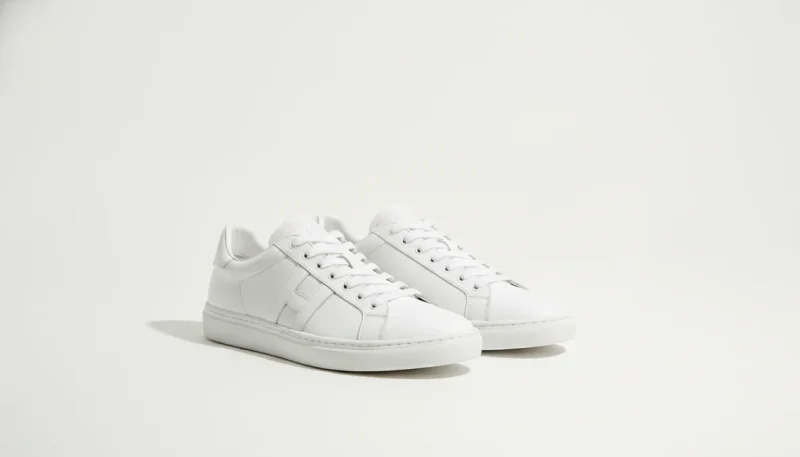 Sneakers bianche classiche su sfondo minimal, guida completa alle scarpe versatili per uomo e donna